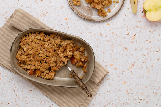 Baked apple oat crumble in dish with fresh apple