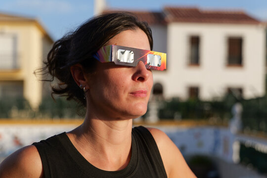 woman looking solar eclipse with protective glasse