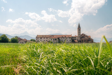 Abbaye de Staffarda vue depuis un champ d'herbe verte, Piemont, Italie