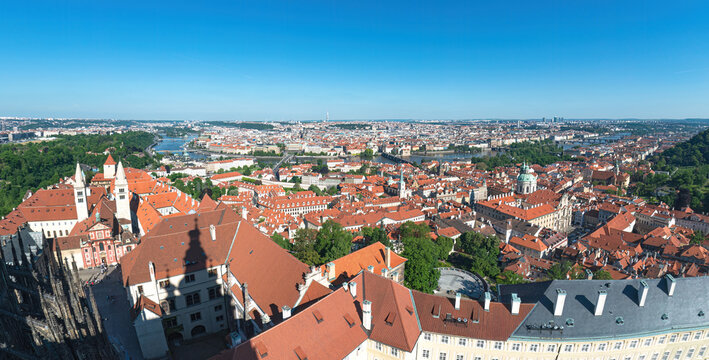 Panoramic view of Prague embracing the Vltava river and its bridges under a clear blue sky