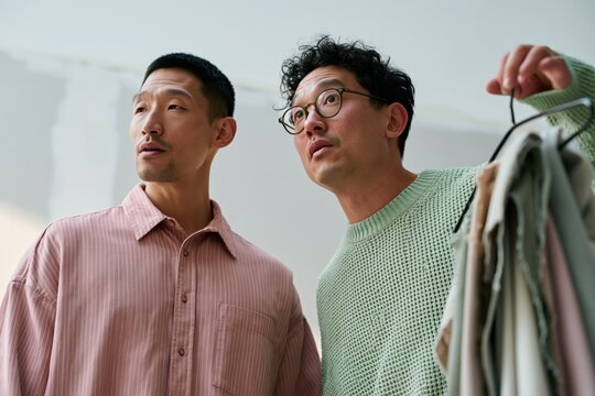 Two men comparing clothing samples for fashion retail and wardrobe styling background for catalog and lookbook design