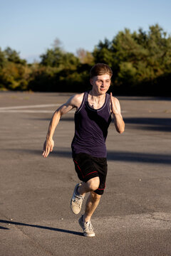 Teenage boy wearing sports clothing running forwards