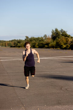 Teenage boy wearing sports clothing running forwards