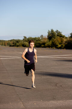 Teenage boy wearing sports clothing running forwards