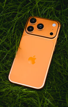 KYIV, UKRAINE - July 10, 2026 : Apple iPhone 17 Pro in Cosmic Orange color on fresh green grass outdoors.