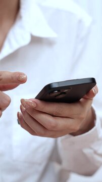 woman holds smart phone in her hands and scrolls through the news feed. Close up of hand uses mobile. point finger on screen, texting text message.	
