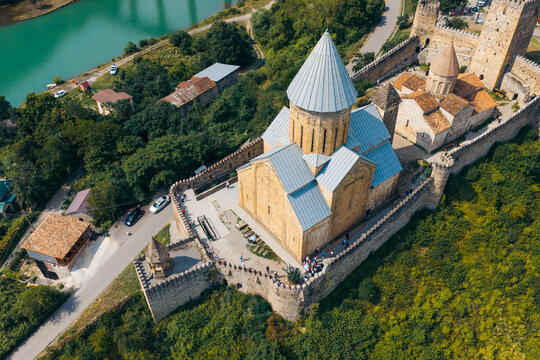 Aerial view of Ananuri Fortress Complex featuring historic stone walls, a church with a conical roof, and lush greenery near the river in Ananuri, Mtskheta-Mtianeti, Georgia.