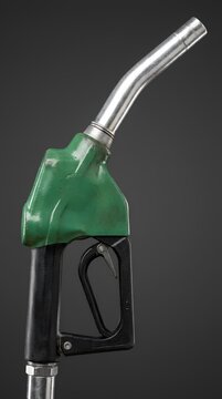 Green fuel pump nozzle isolated on black background.