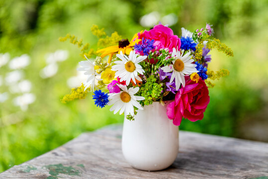 Beautiful bouquet with summer wild flowers and margaritas on green background	