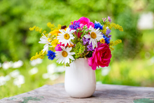 Beautiful bouquet with summer wild flowers and margaritas on green background	