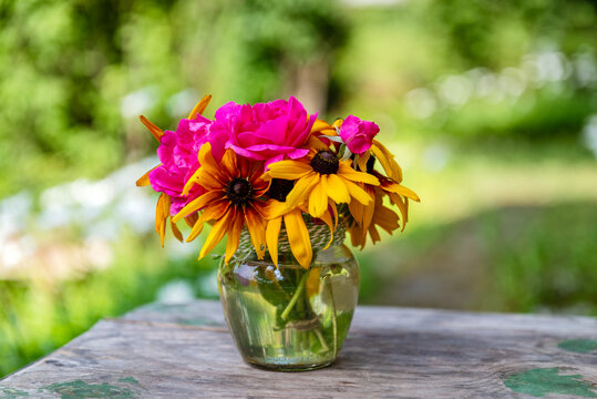 Beautiful bouquet with yellow margaritas and red roses  on green background	