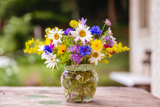 Beautiful bouquet with summer wild flowers and margaritas on green background	