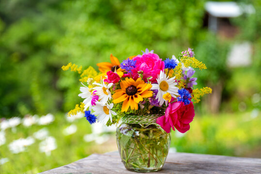 Beautiful bouquet with summer wild flowers and margaritas on green background	