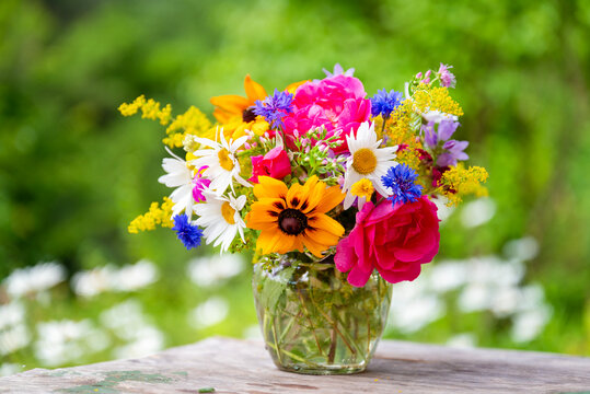 Beautiful bouquet with summer wild flowers and margaritas on green background	