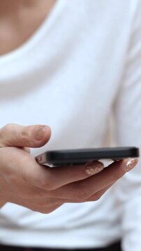 woman holds smart phone in her hands and scrolls through the news feed. Close up of hand uses mobile. point finger on screen, texting text message.	
