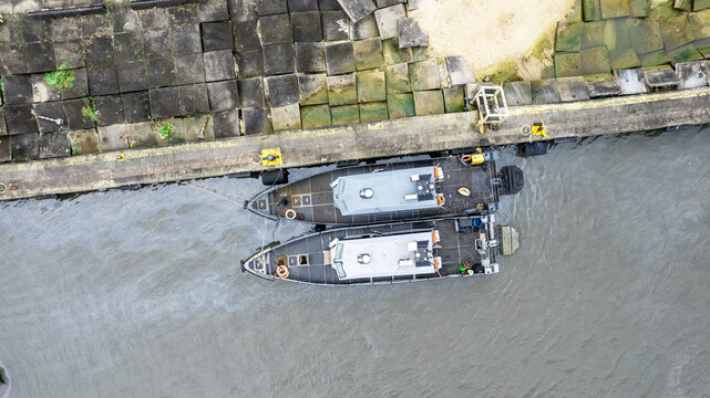 Aerial view of two patrol boats docked at the Nigerian Ports Authority pier, featuring concrete blocks along the quay in Port Rivers, Rivers, Nigeria.