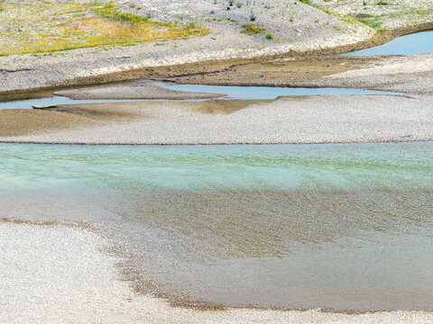 Aerial view of the Drina river with shallow turquoise water flowing over gravel banks and sandbars in Crna Bara, Macva District, Serbia.