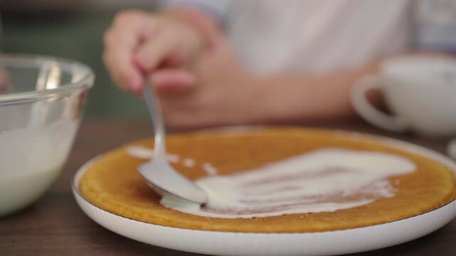 Close-up: pouring cream over golden pancake, tactile texture, 25 fps