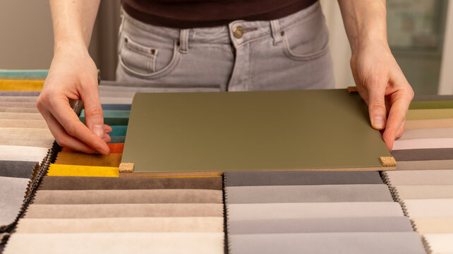 Upholstery material swatch palette for modern interior project. Designer adjusting green color board