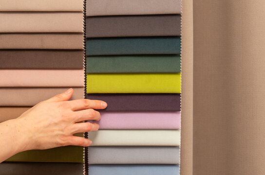 Upholstery tissue swatch selection for home renovation order. Hand touching colorful fabric samples