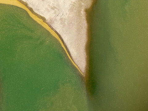Aerial view of the Drina riverbank with sandy deposits and green water in Crna Bara, Macva District, Serbia.