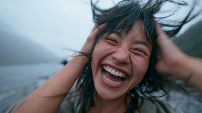 Joyful Young Woman Laughing Outdoors in the Wind