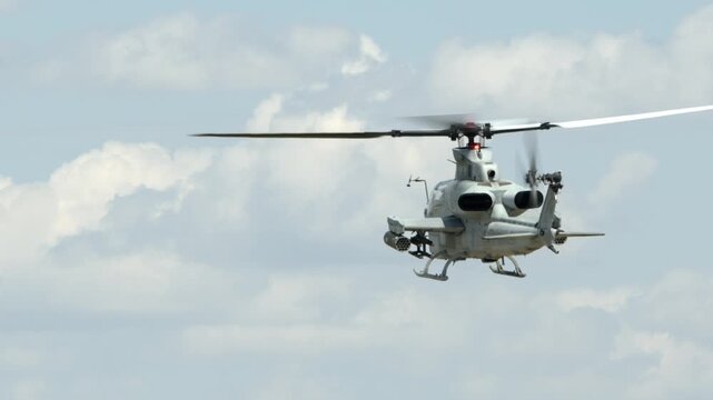 A United States Marines Bell AH-1 Cobra attack helicopter in flight, rear slow motion view.
