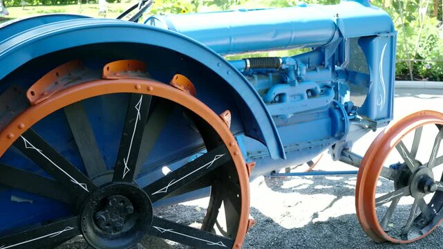 Restored vintage blue tractor with steel wheels outdoors