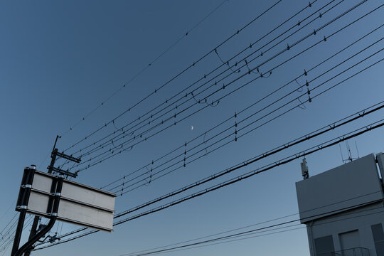 青空を背景にそびえる野球場の防球ネットと照明塔