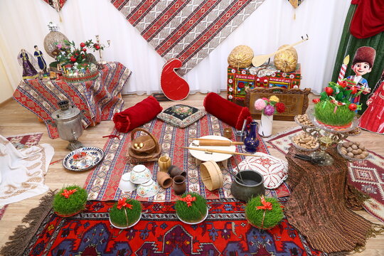Authentic Azerbaijani Novruz holiday composition featuring traditional carpets, semeni grass, musical instruments, and samovar. Spring festival interior background with rich ethnic cultural ornaments.