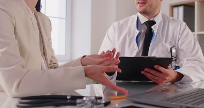Doctor or nurse provides medical consultation and appointment for patient in clinic, offering support and healthcare aid in a professional setting with focus on care and attention.