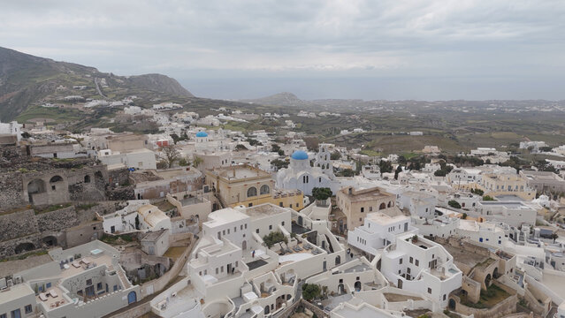 Aerial view of the historic village of Pyrgos Kallistis with its traditional white-washed buildings, blue-domed churches, and winding streets on the hillside in Pyrgos Kallistis, Greece.