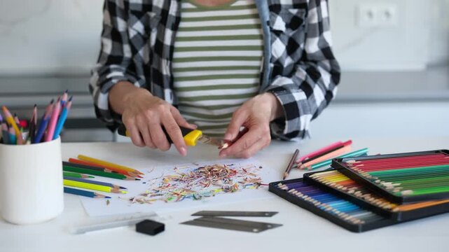 Close-Up Of A Woman Sharpening Colored Pencils