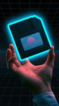 A hand holds a glowing retro floppy disk with a digital sunset design against a dark grid background in a creative synth wave style