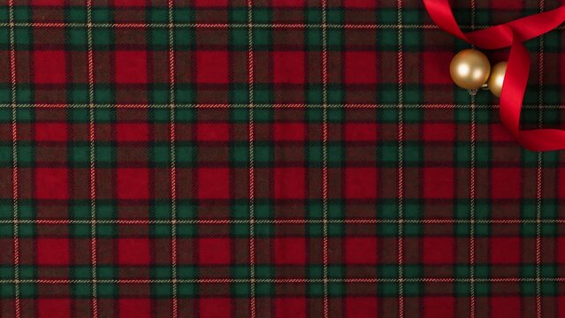 Classic red plaid fabric background with silk ribbon and golden holiday baubles