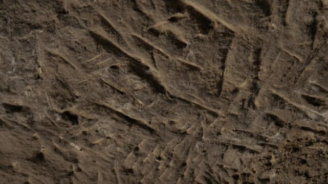 Handheld close-up shot of heavily scratched sandstone cave walls in the ancient city of Uplistsikhe, Georgia.