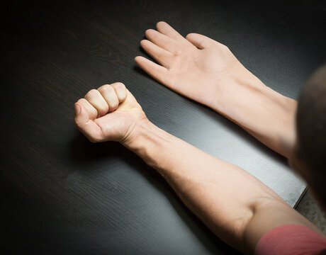 Conflict resolution, choice, and body language concept showing clenched fist and open palm gestures