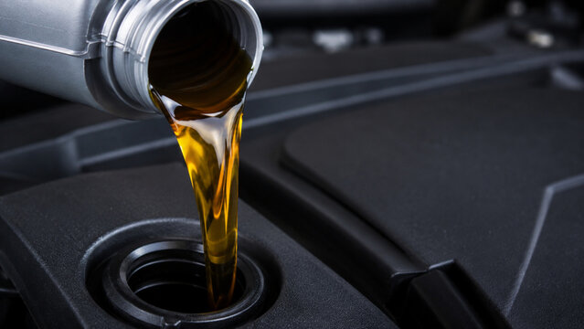 Close Up of Fresh Engine Oil Pouring Into Car Engine During Maintenance
