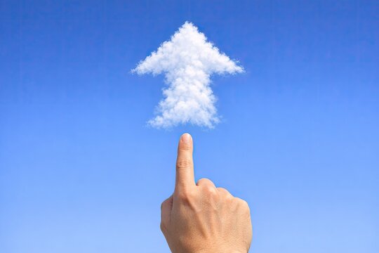 A person's hand points at a cloud resembling a small house, possibly indicating a desire or intention