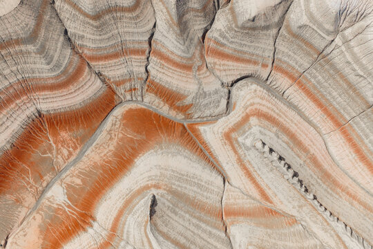 Aerial view of Tiramisu Hills featuring intricate, colorful sedimentary rock layers and eroded desert terrain in Kyzylkum, Mangystau Region, Kazakhstan.