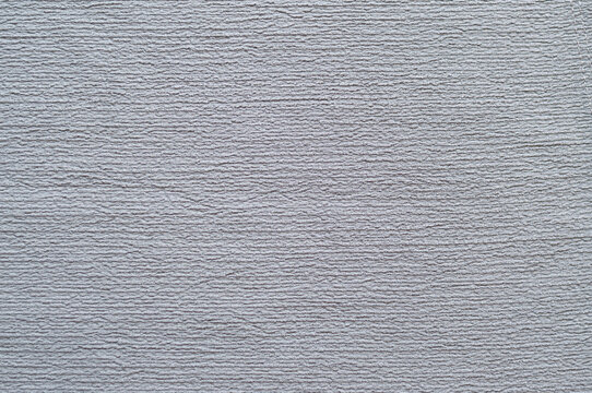Close-up texture of grey crinkle crepe fabric, abstract soft ribbed textile background