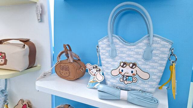 cinnamoroll sanrio light blue woven tote handbag with shoulder strap and hello kitty mini pouch on retail store display shelf on August 17, 2026 in Bangkok, Thailand.