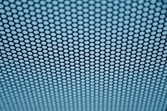 perforated metal surface with circular hole grid, shallow depth of field, clean minimal industrial abstract background Black and light blue perforated metal iron mesh backdrop