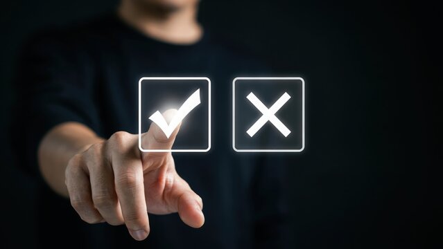 A person in a black shirt touching a glowing digital interface with a checkmark and an x symbol, making a decision or choosing an option