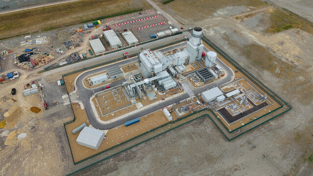 Aerial view of Millbrook Power Plant featuring industrial infrastructure, storage tanks, and surrounding fenced grounds in Stewartby, England, United Kingdom.