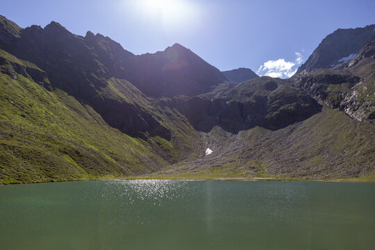 Kleiner Gletschersee vor dem Berg im Gegenlicht