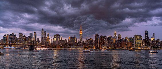 Naklejka premium Dramatic Manhattan Skyline at Dusk Beneath Dark Storm Clouds