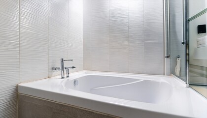 Fototapeta premium a clean white bathroom with a sealed bathtub and tile joint