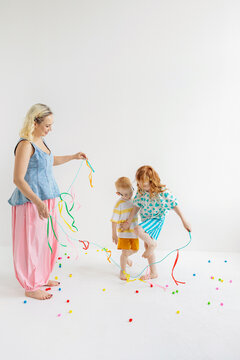Mother and children playing with colorful ribbons
