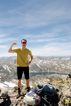 UGC Man flexing on Pic Carlit summit with French Pyrenees lake view